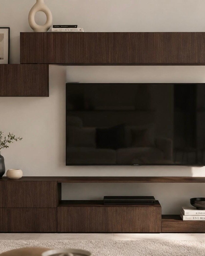 Dark wood wall unit with a wall-mounted television and shelving